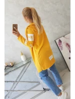 Plášť s hořčičným nápisem