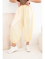 Dámské široké kalhoty s gumou v pase a zavazováním ve stylu aladinek žluté Dámské široké kalhoty s gumou v pase a zavazováním ve stylu aladinek žluté