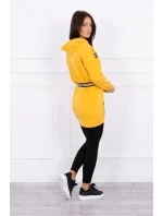 Šaty zdobené stuhou a nápisy v hořčicové barvě Šaty zdobené stuhou a nápisy v hořčicové barvě